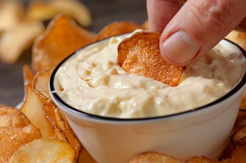 Crisp being dunked into dip