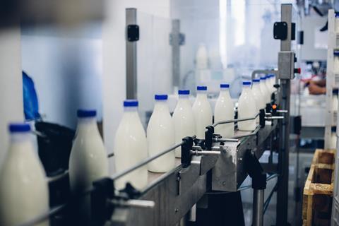 milk bottles on conveyer- getty