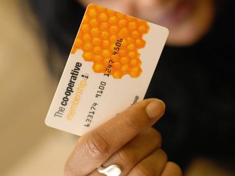 co-op employees voting at agm, woman holding co-op card