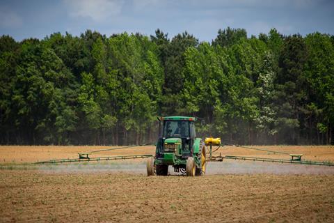 tractor spraying crops in field
