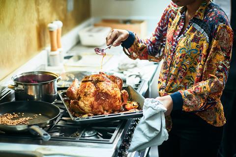 woman basting turkey on top of oven
