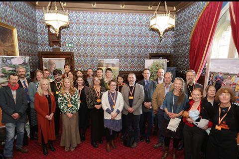 A group of people standing in a room marking the opening of an event