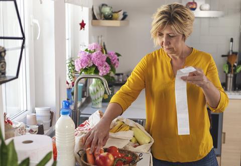 Getty woman going through her receipts at home after buying groceries