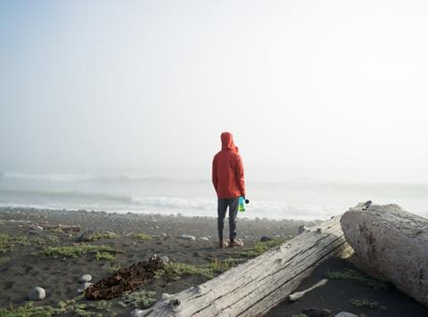 person on beach with reuseable bottle