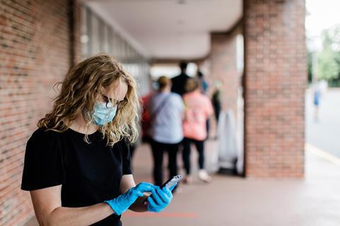 shopper in queue mask gloves phone