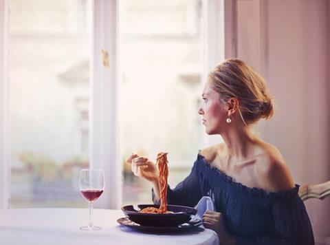 woman eating spaghetti wine restaurant