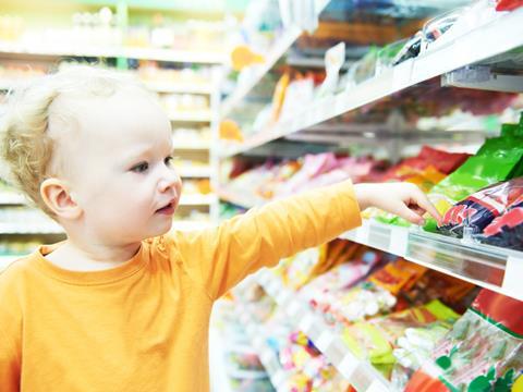 child in supermarket sweets 