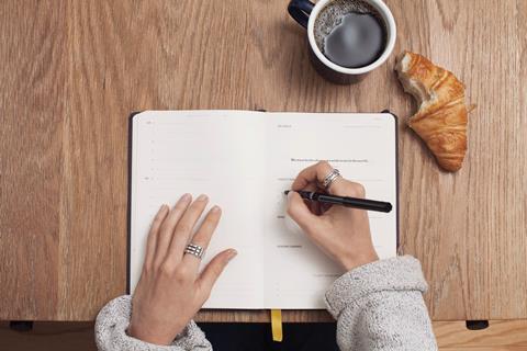 woman writing coffee croissant